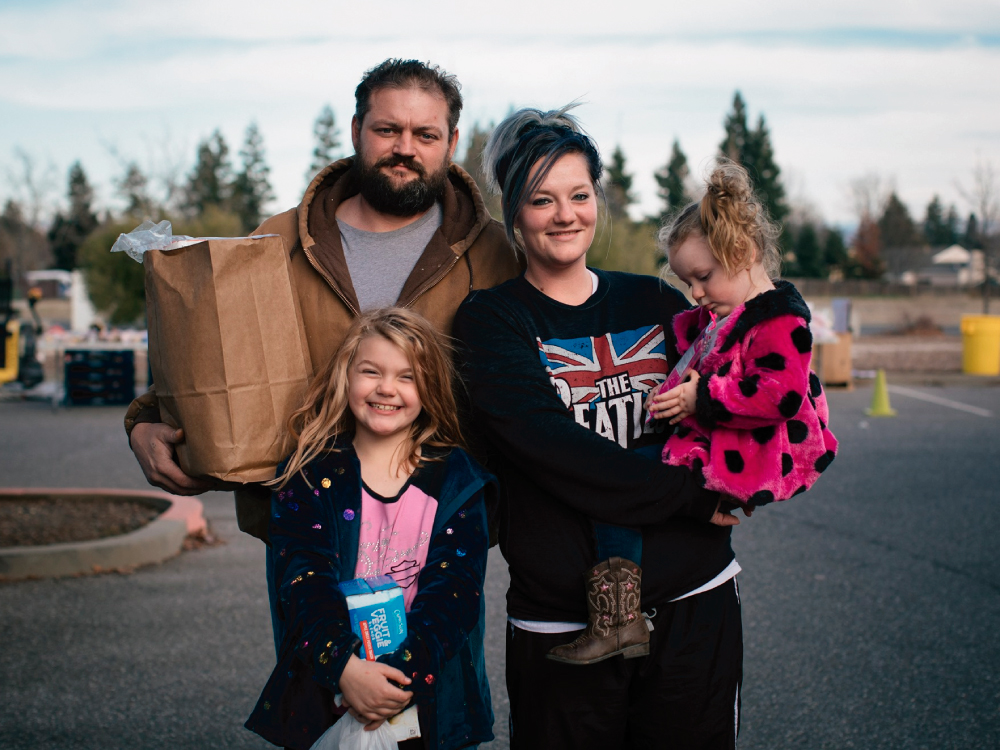 Family Holding Bag of Food
