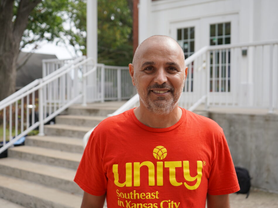 Man smiling in front of church building wearing Unity Southeast t-shirt.